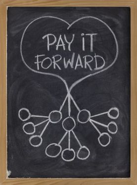 pay it forward concept illustrated with white chalk drawing on blackboard